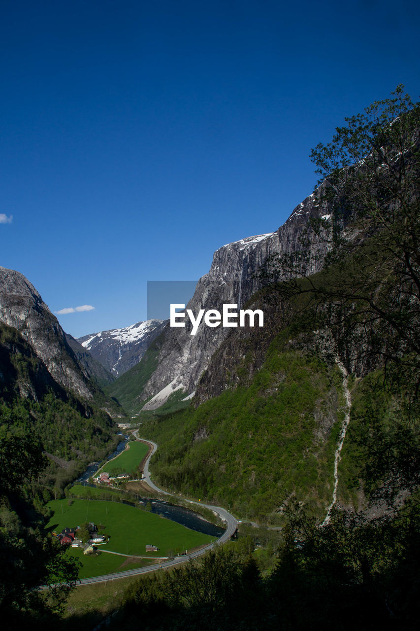 Scenic view of mountains against clear blue sky