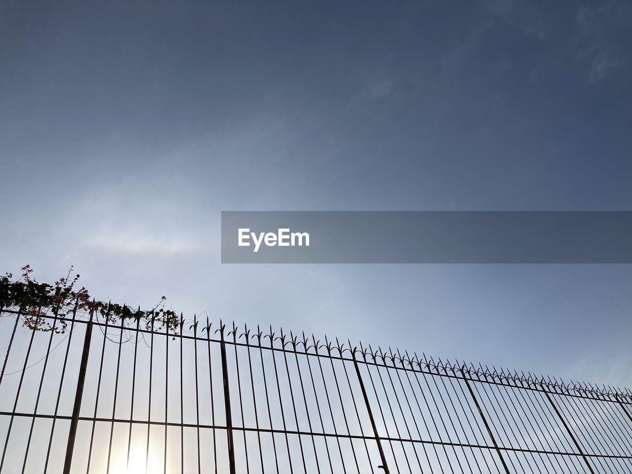 LOW ANGLE VIEW OF METAL FENCE AGAINST SKY