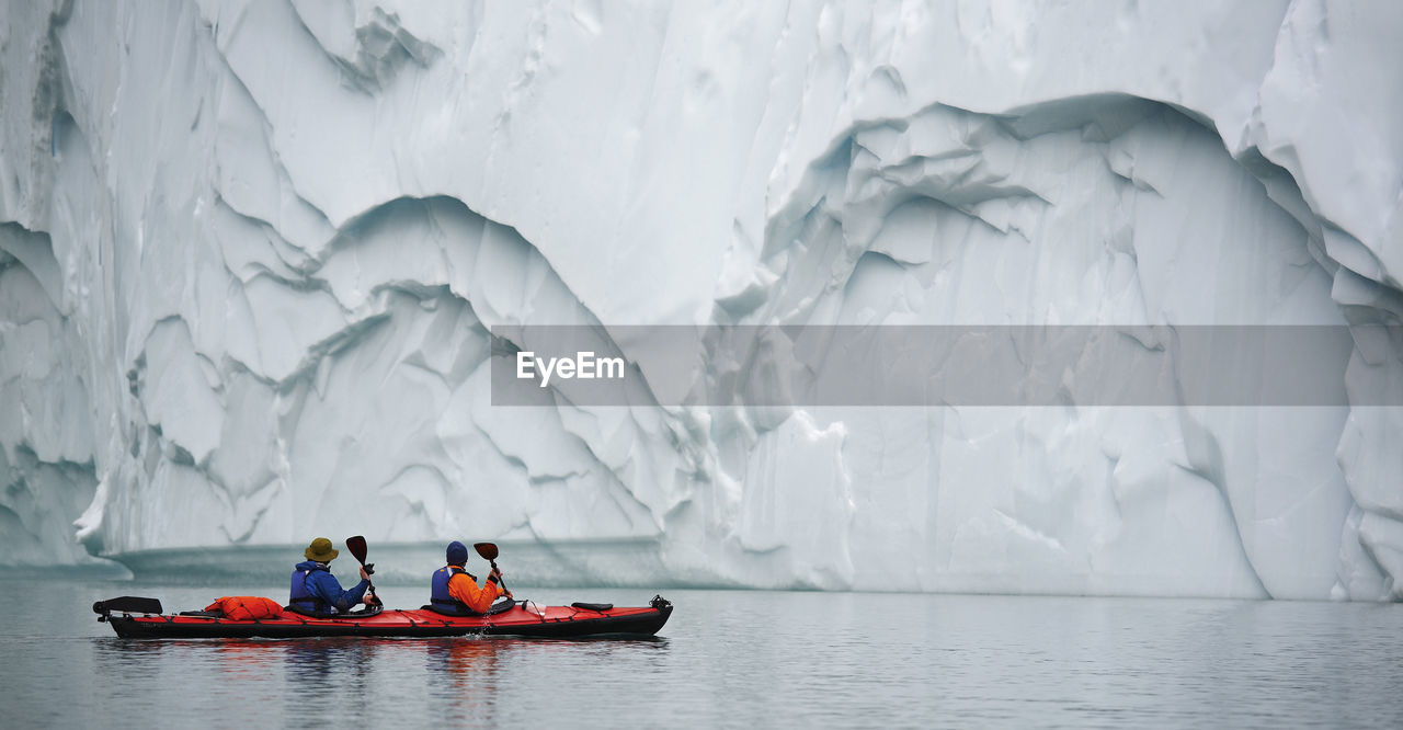 2 men traveling with a sea kayak in eastern greenland