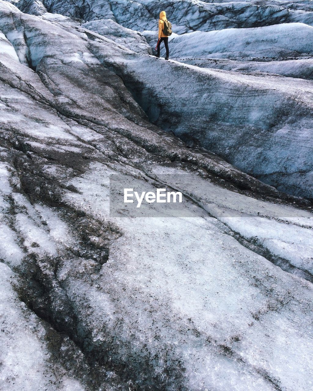 Rear view full length of person walking on snowcapped mountain