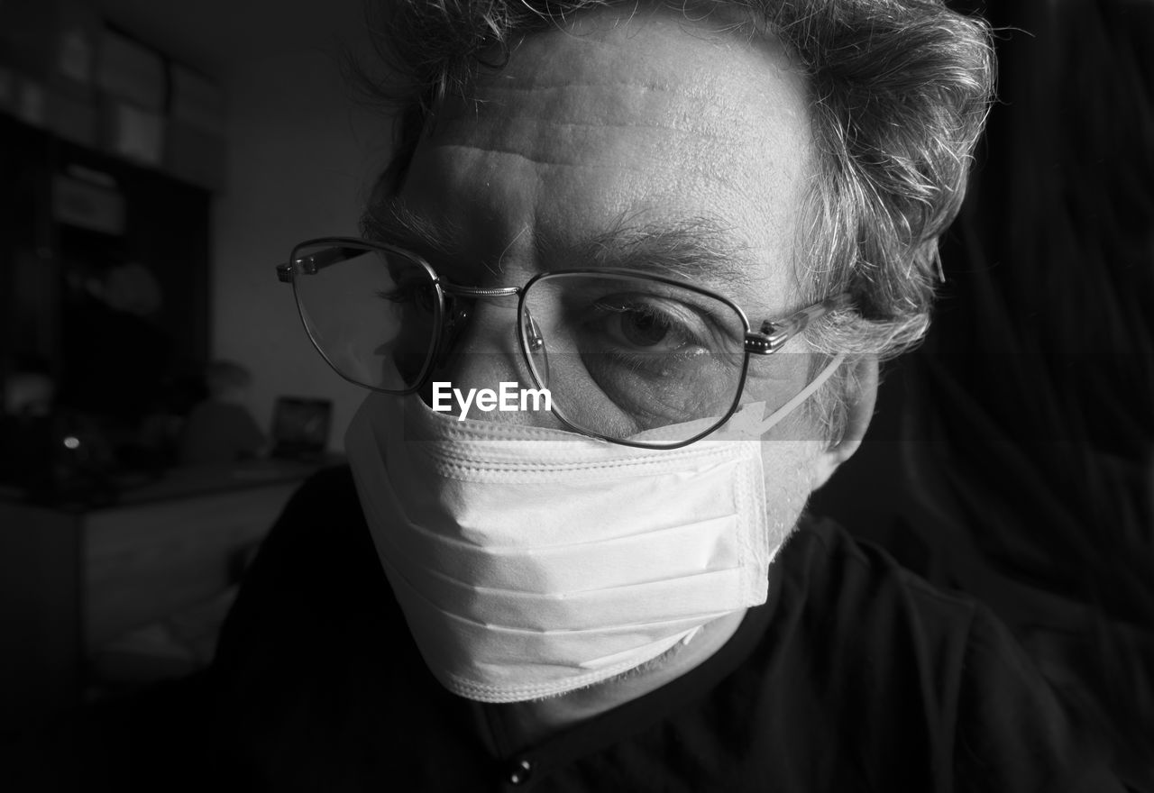 Close-up of mature man wearing flu mask at home
