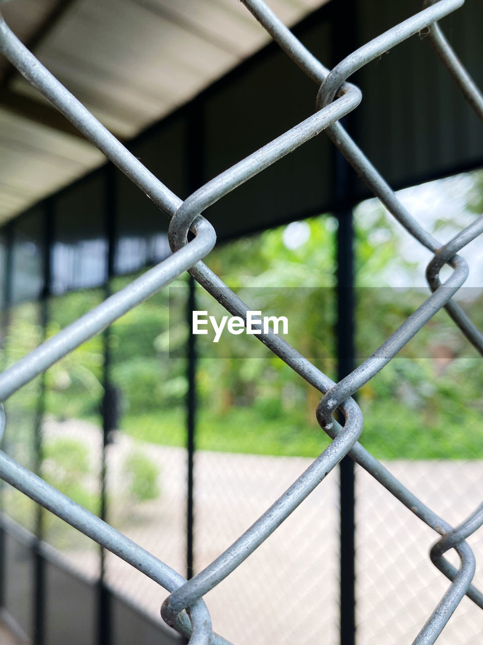 CLOSE-UP OF CHAINLINK FENCE AGAINST RAILING