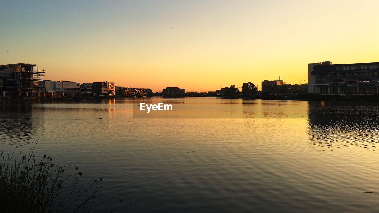 Scenic view of river against clear sky during sunset