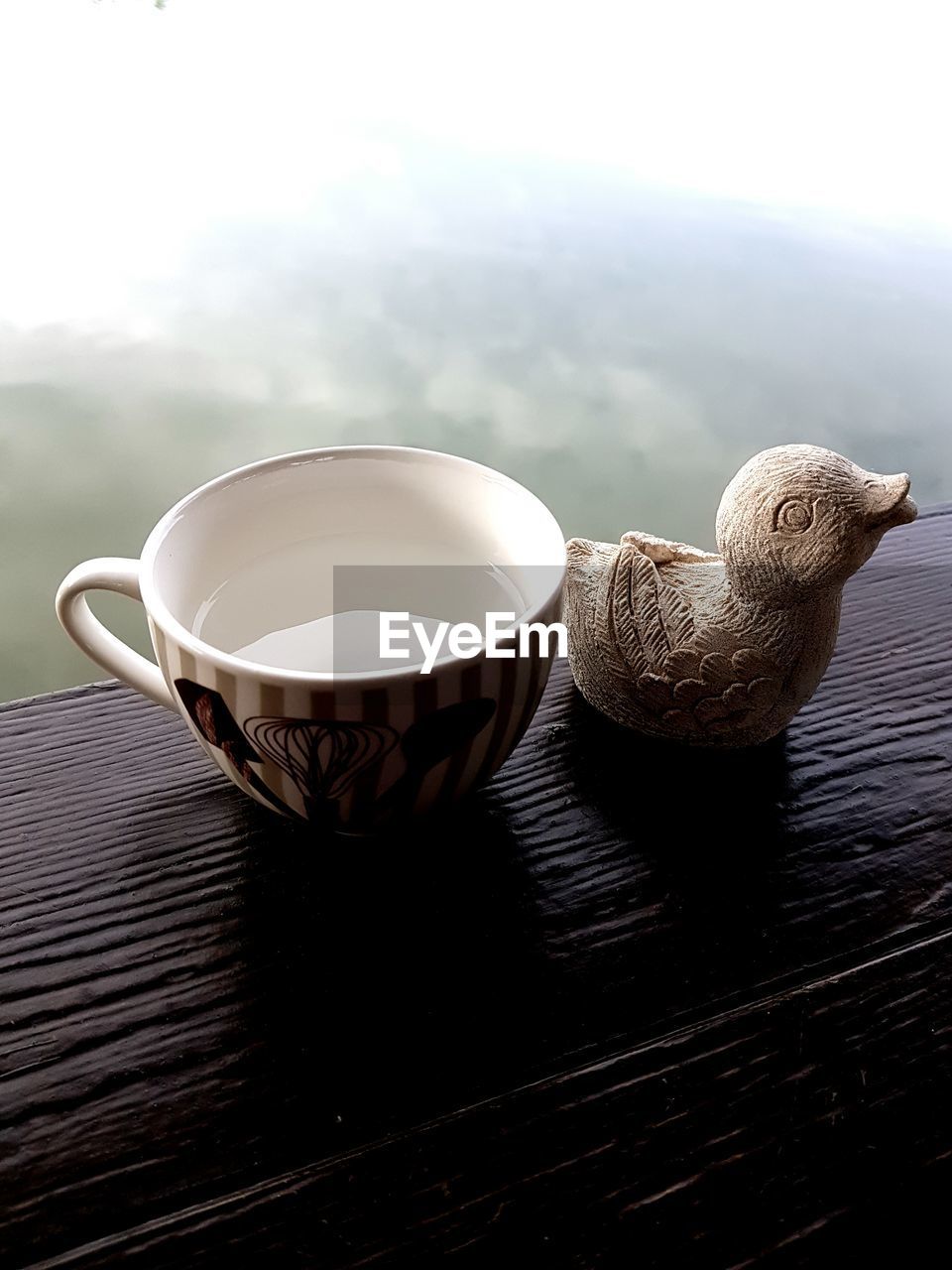 CLOSE-UP OF COFFEE CUP ON TABLE AGAINST WALL