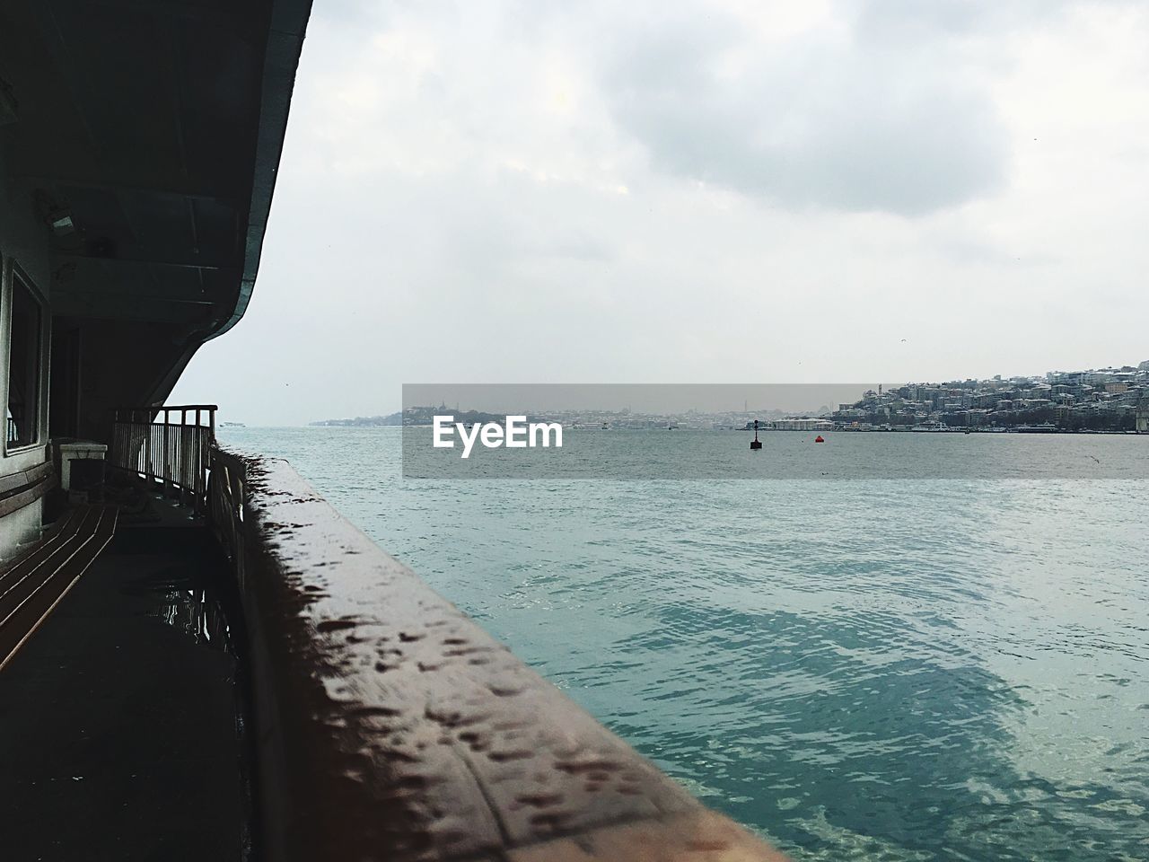 Cropped image of wet ferry in sea against sky during monsoon