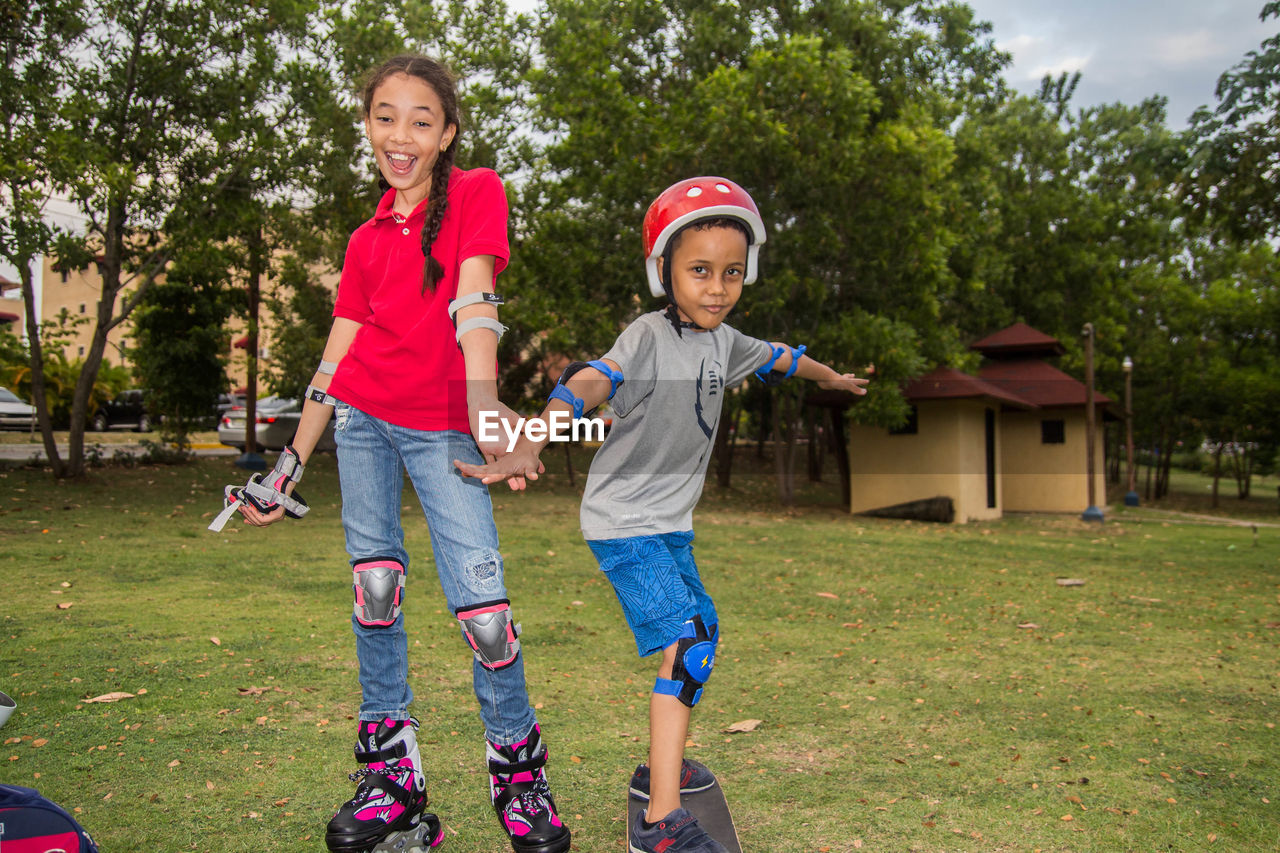 Portrait of a smiling siblings girl and boy standing outdoors