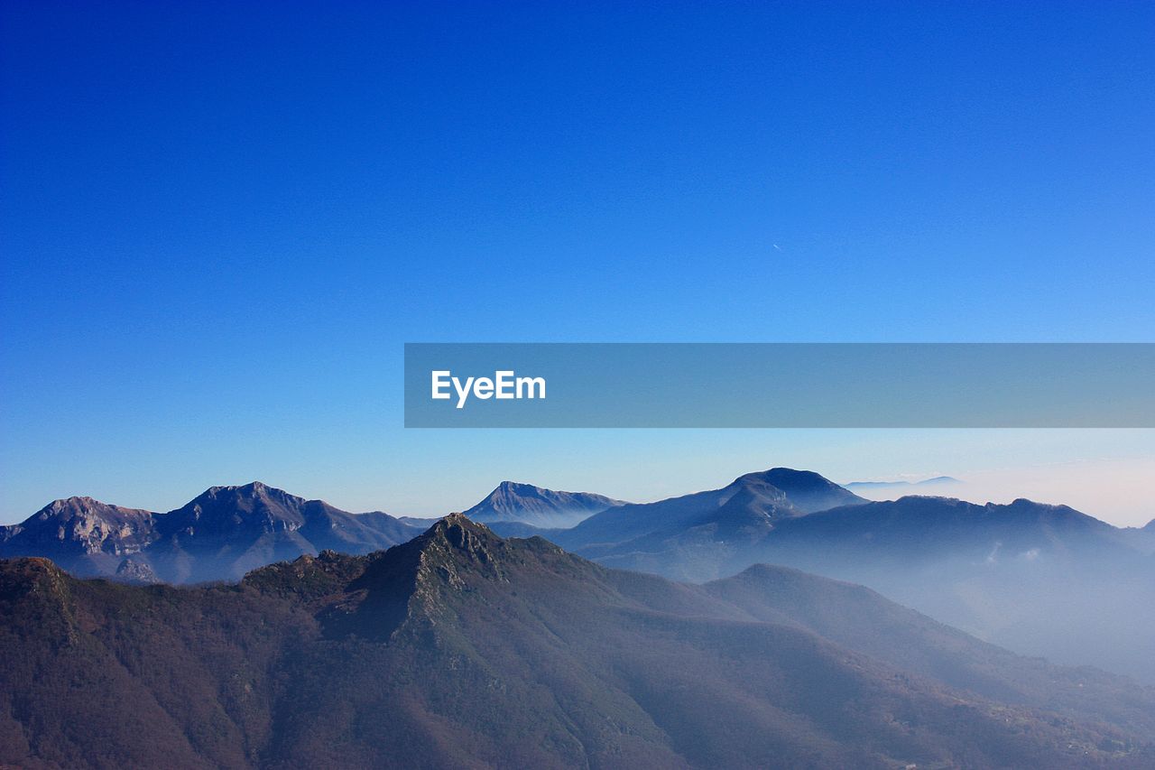 Scenic view of mountains against clear blue sky