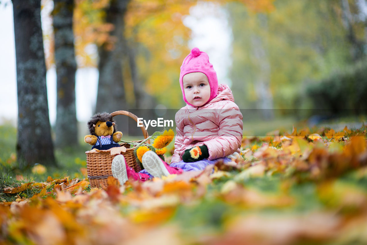 Cute baby girl sitting on field at park