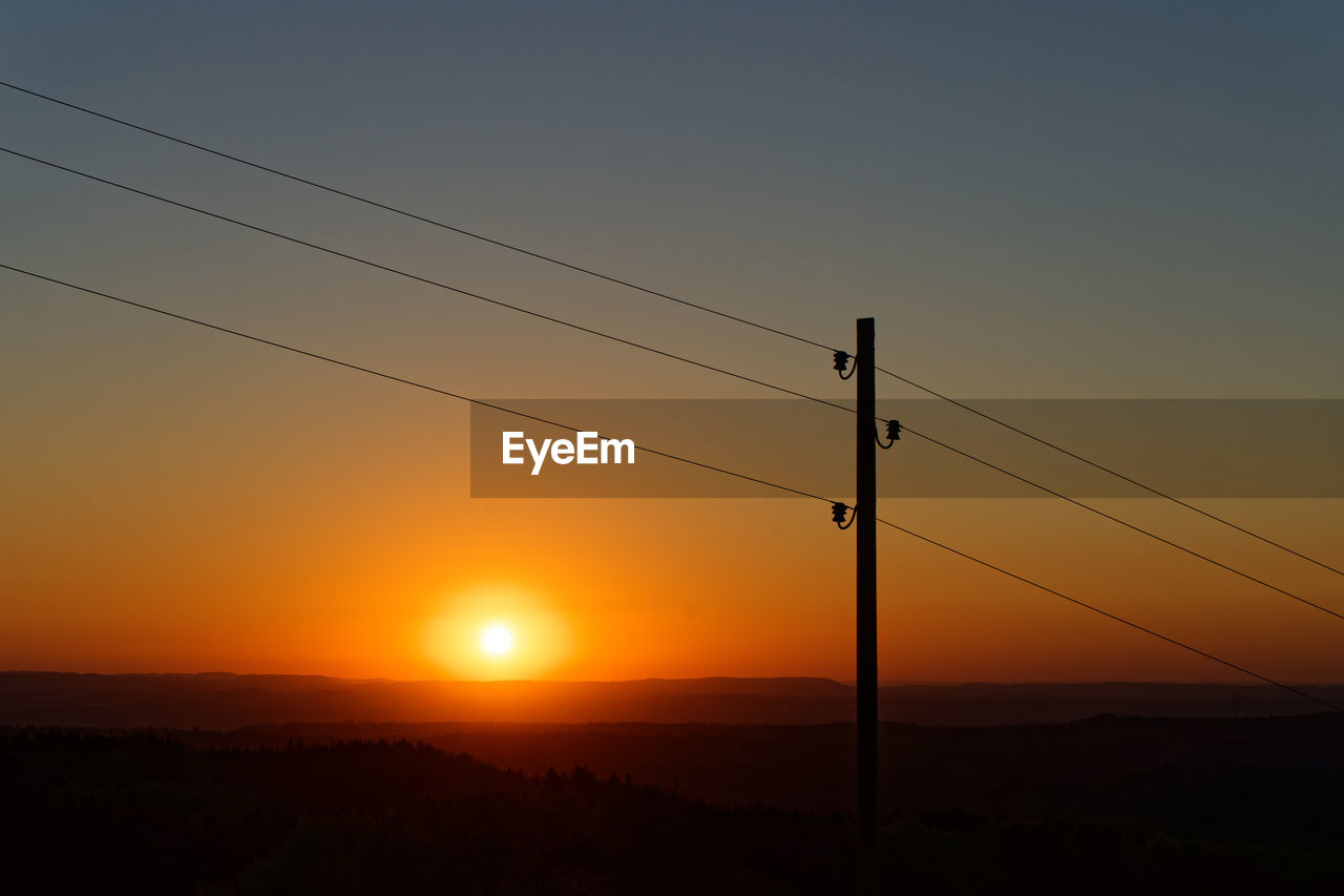 Power line in front of sunset