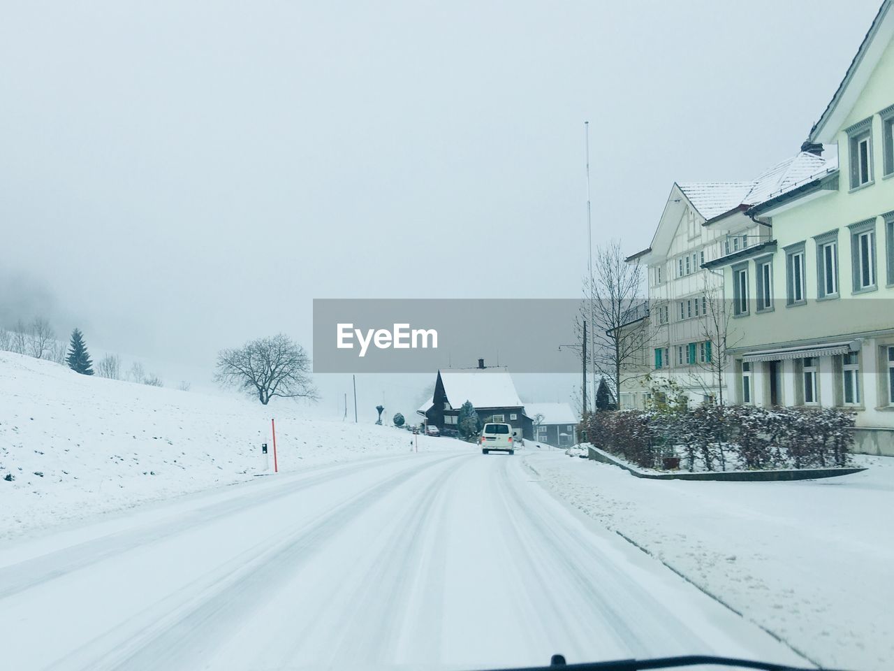 Cars on road against clear sky during winter