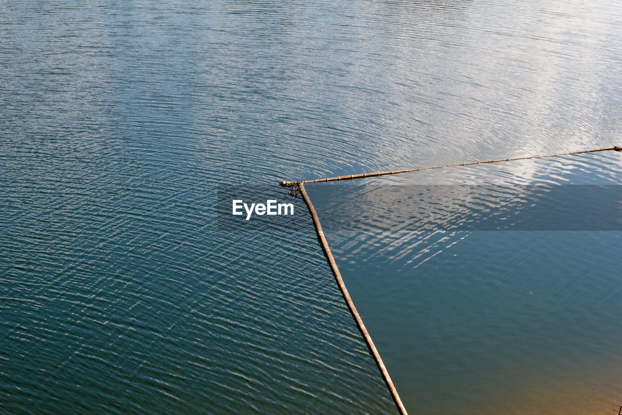 HIGH ANGLE VIEW OF FISHING NET IN SEA