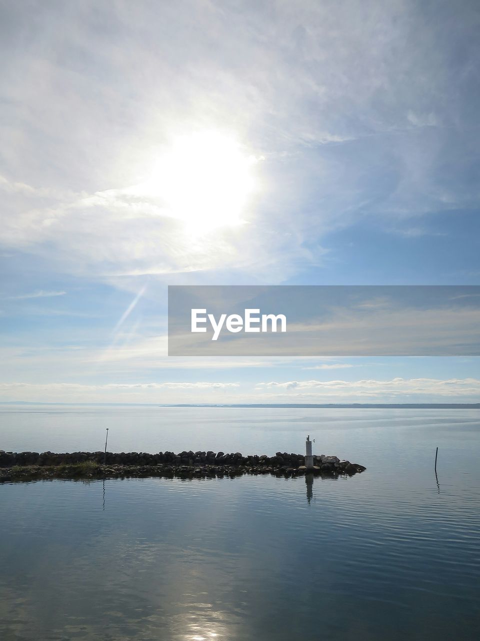 Idyllic shot of groyne in sea against sky