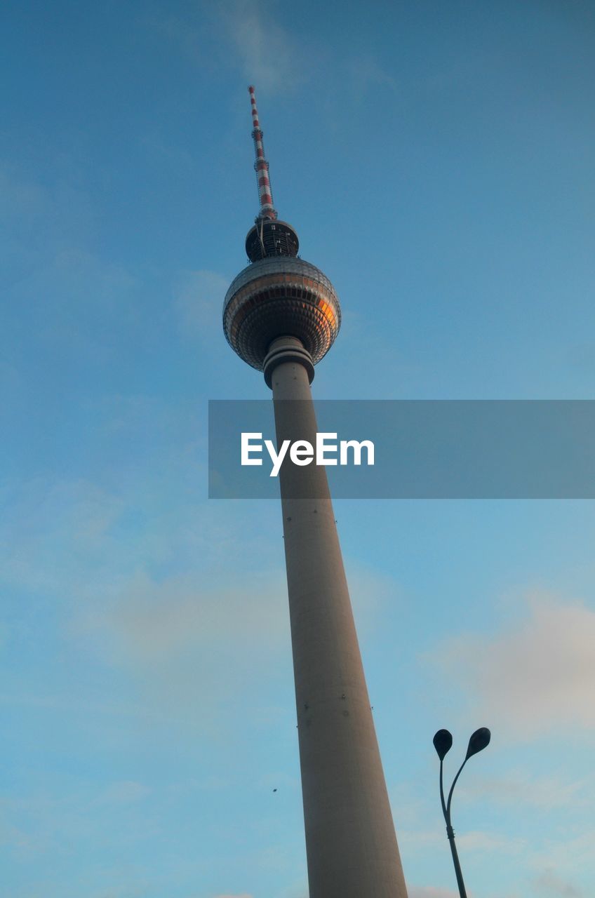 LOW ANGLE VIEW OF COMMUNICATIONS TOWER IN CITY AGAINST SKY