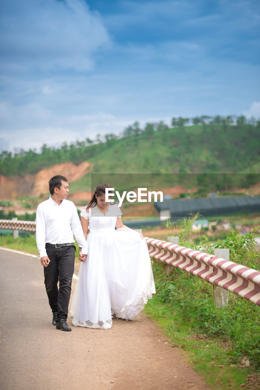 Couple  standing on road against sky