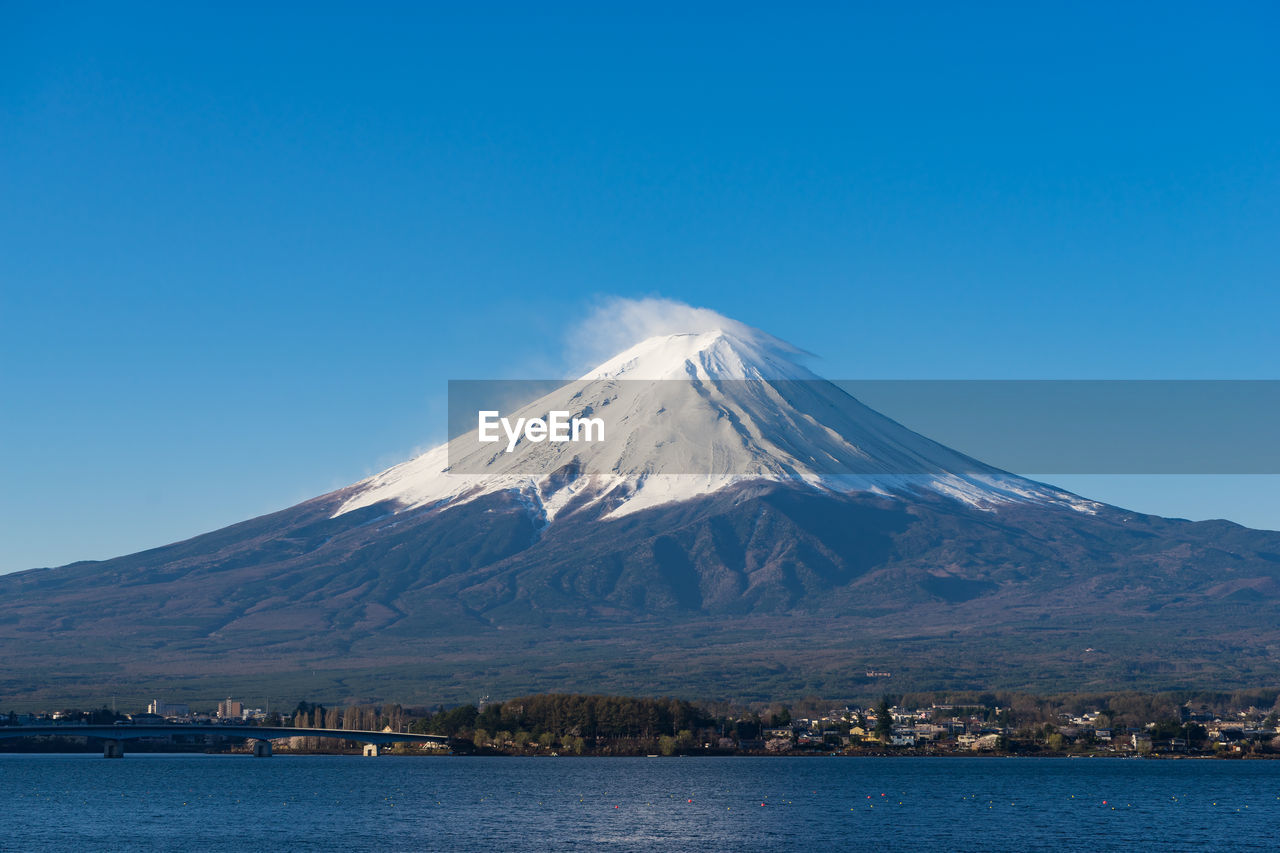 Scenic view of snowcapped mountain against blue sky