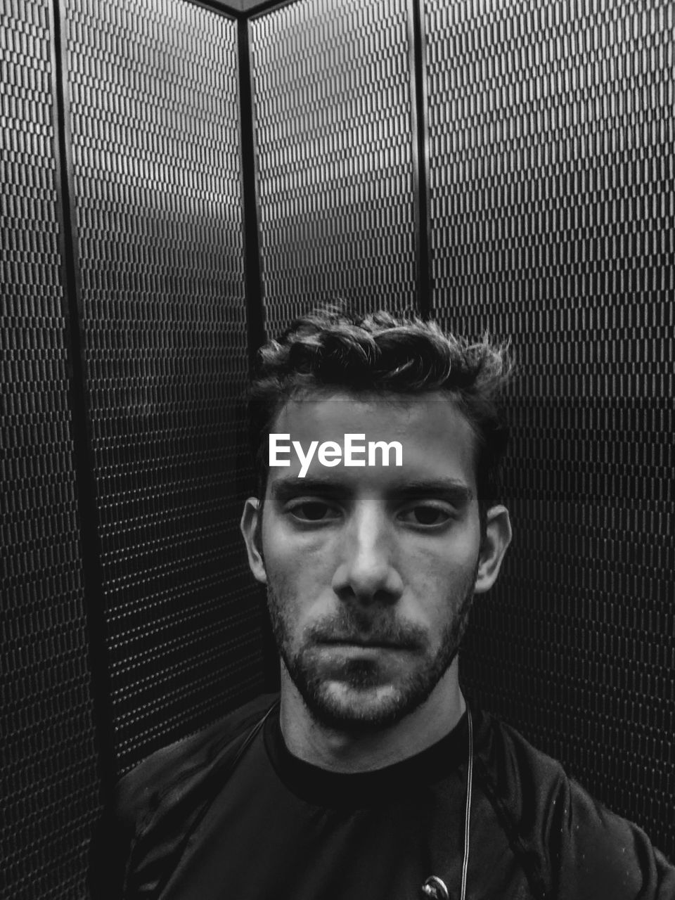 Portrait of serious young man in elevator