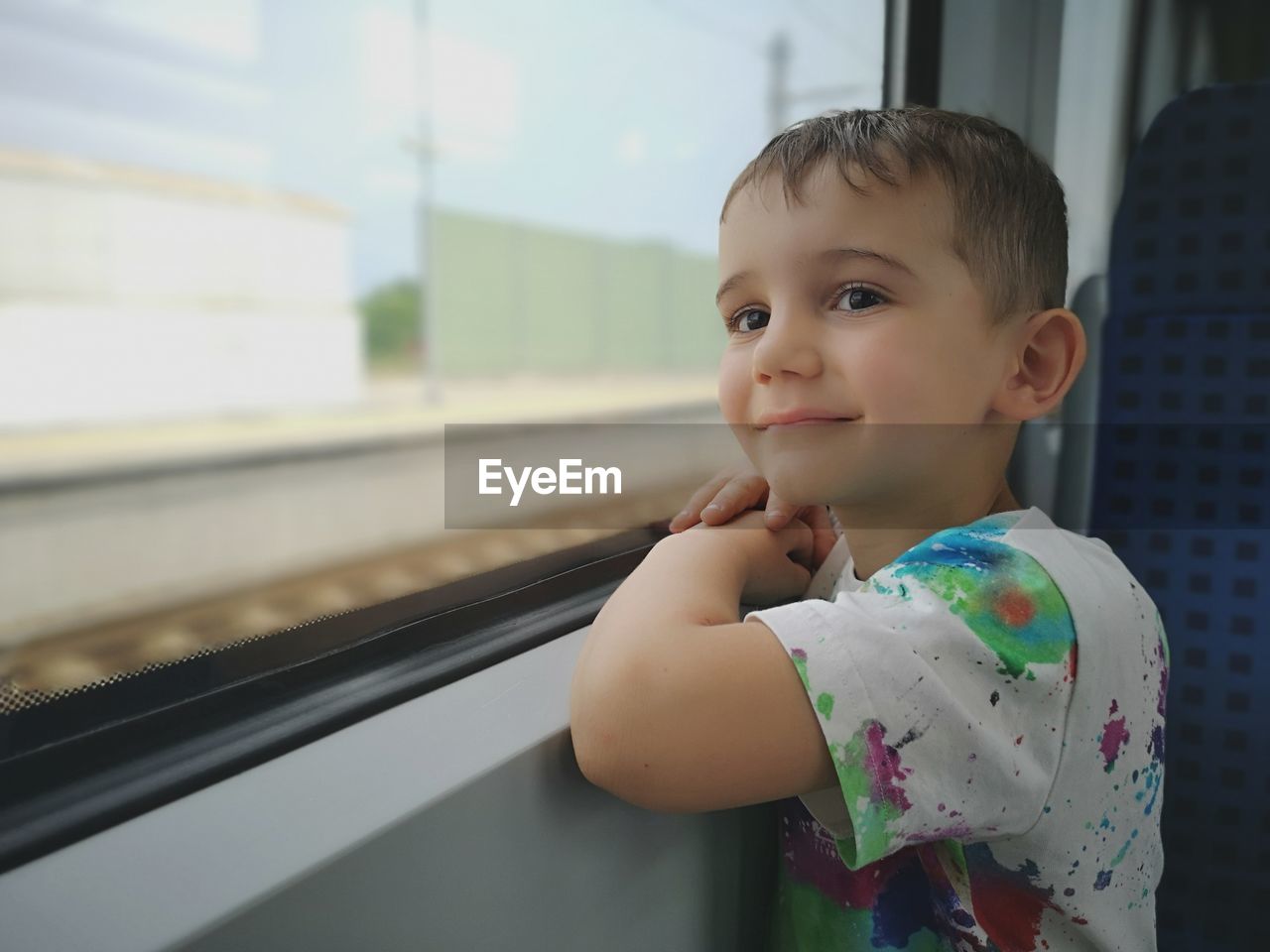 Side view of boy by window in train