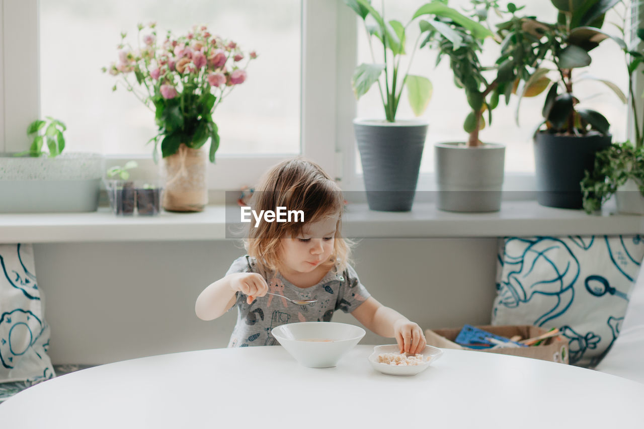 portrait of cute baby girl sitting on table