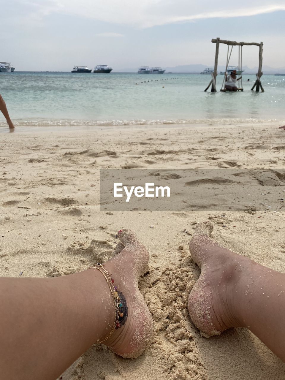 human leg, low section, sand, beach, land, one person, human limb, nature, limb, human foot, lifestyles, hand, personal perspective, water, barefoot, adult, day, leisure activity, vacation, trip, women, high angle view, outdoors, sea, holiday, shoe, white