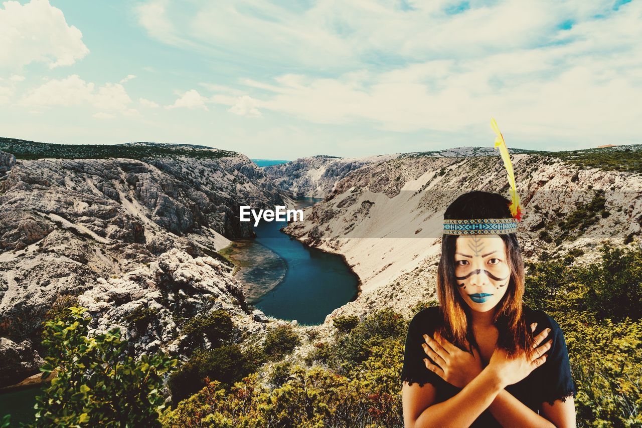 PORTRAIT OF SMILING WOMAN ON ROCK