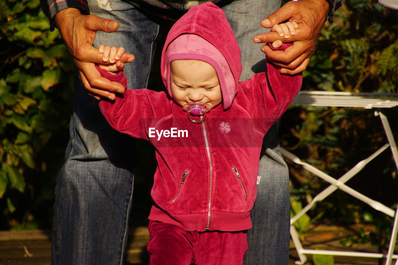 CLOSE-UP OF YOUNG WOMAN HOLDING HANDS