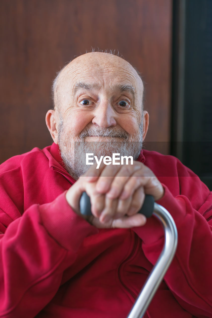 close-up of senior man wearing sunglasses while standing against wall