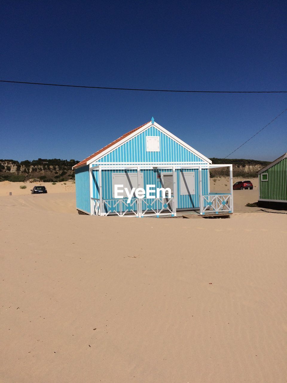 Lifeguard hut at beach against clear blue sky