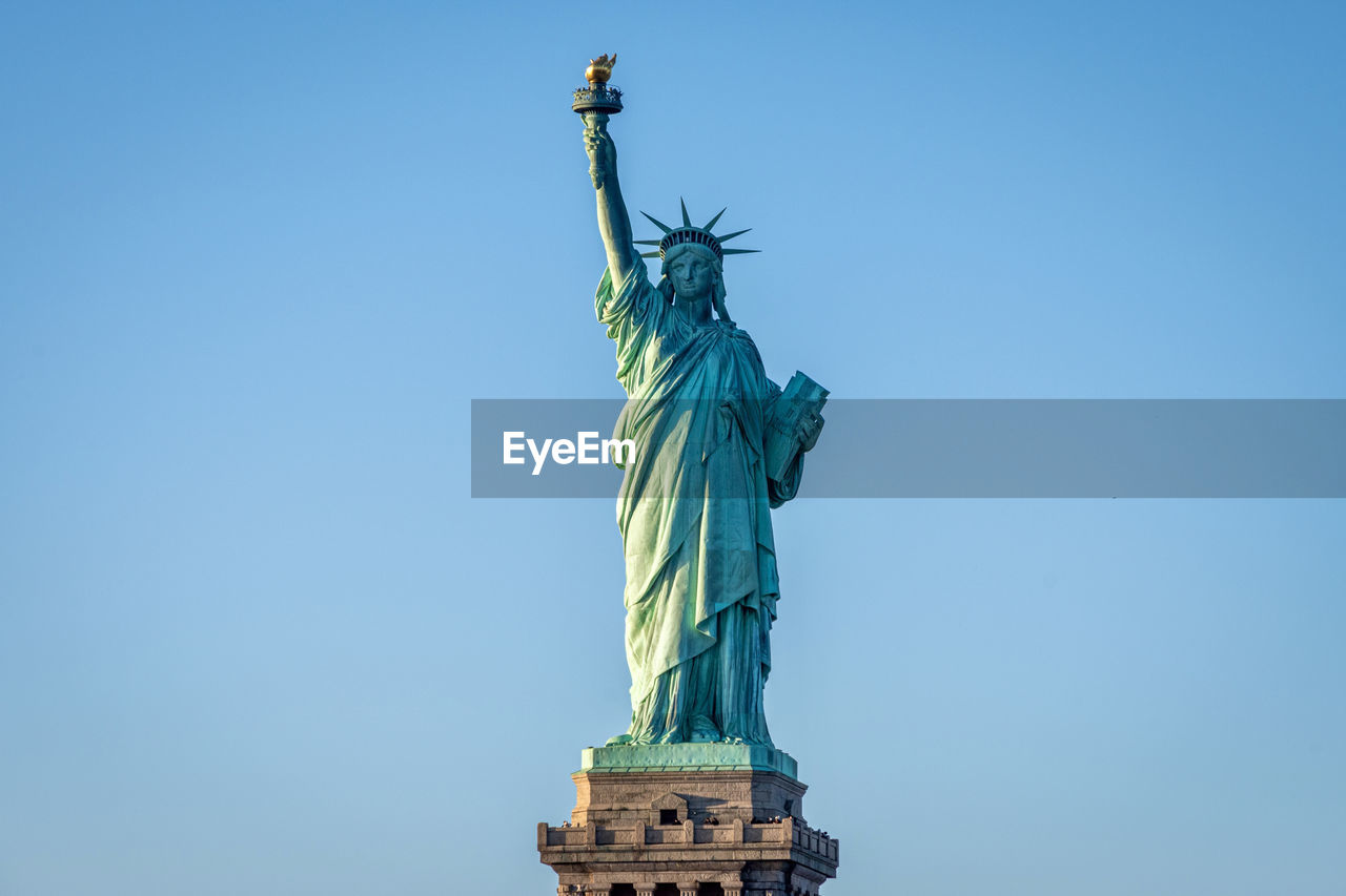 Low angle view of statue of liberty against clear blue sky