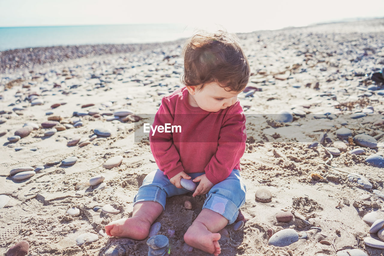 Full length of girl sitting on beach