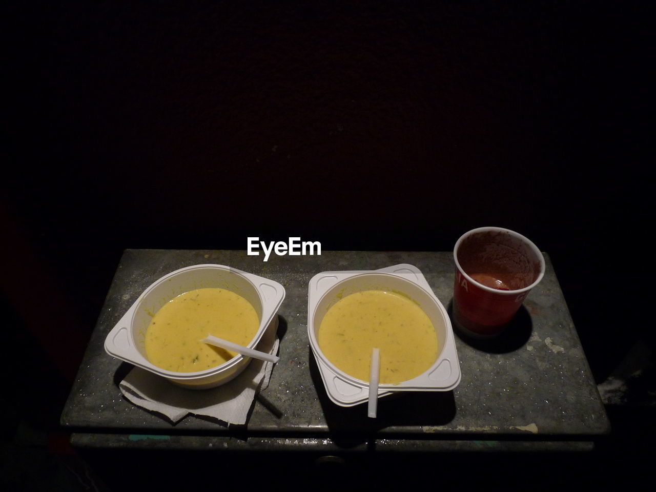 TEA CUP ON TABLE AGAINST BLACK BACKGROUND