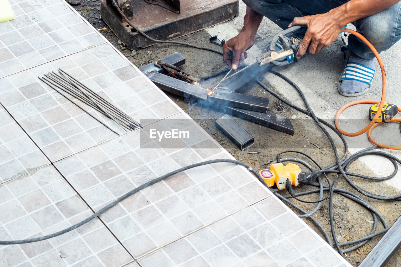 HIGH ANGLE VIEW OF MEN WORKING ON FLOOR