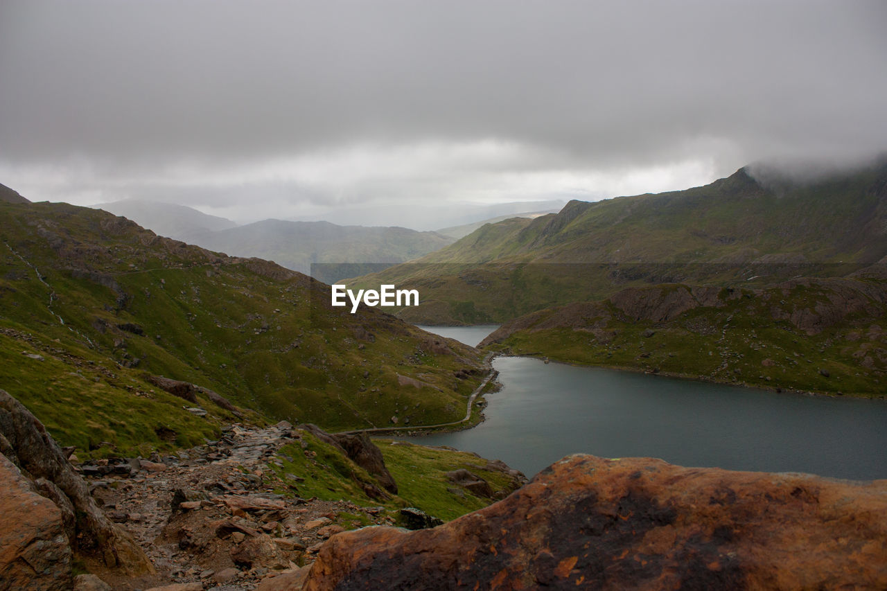 Scenic view of river and mountains against sky