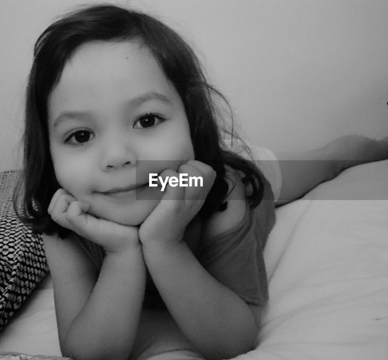 PORTRAIT OF CUTE GIRL SMILING ON BED