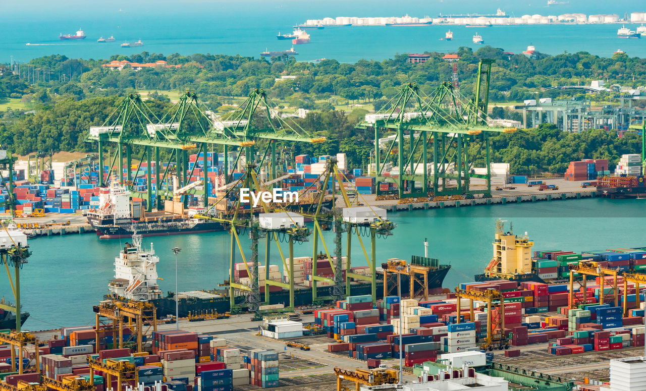 HIGH ANGLE VIEW OF COMMERCIAL DOCK AGAINST BLUE SKY