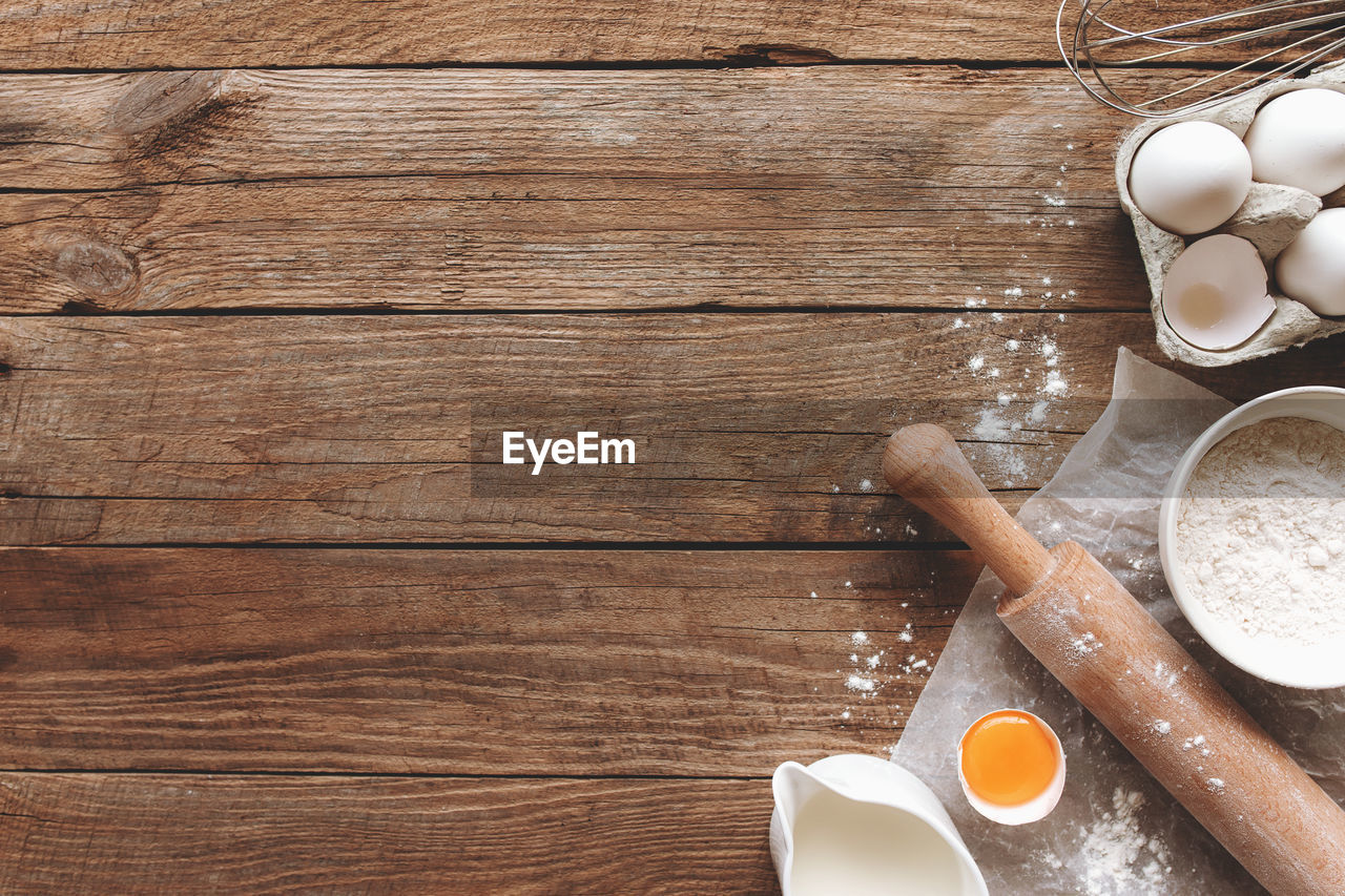 Baking ingredients, kitchen utensils on old wooden background. cooking cake or cookies