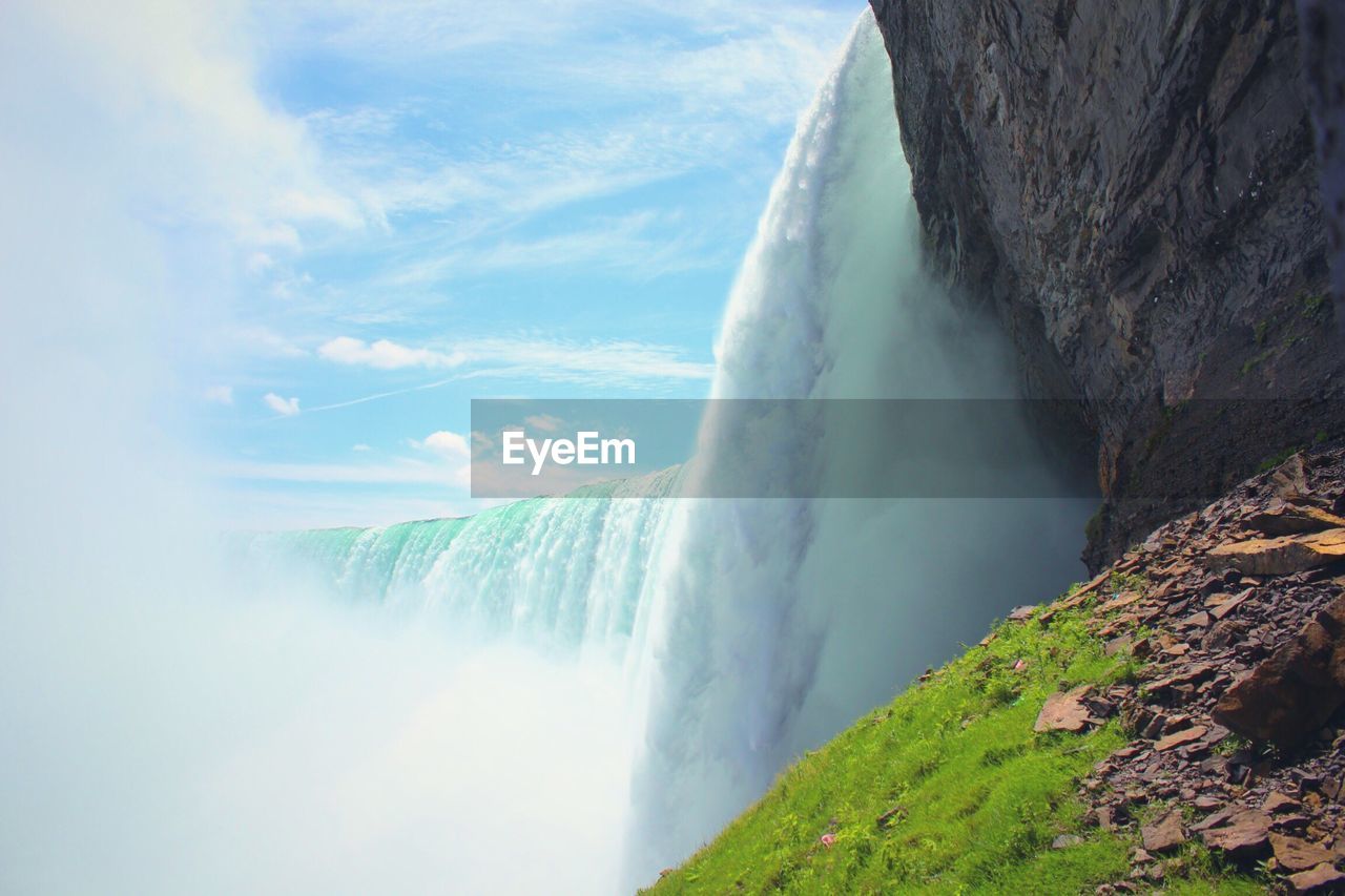 Scenic view of waterfall against sky