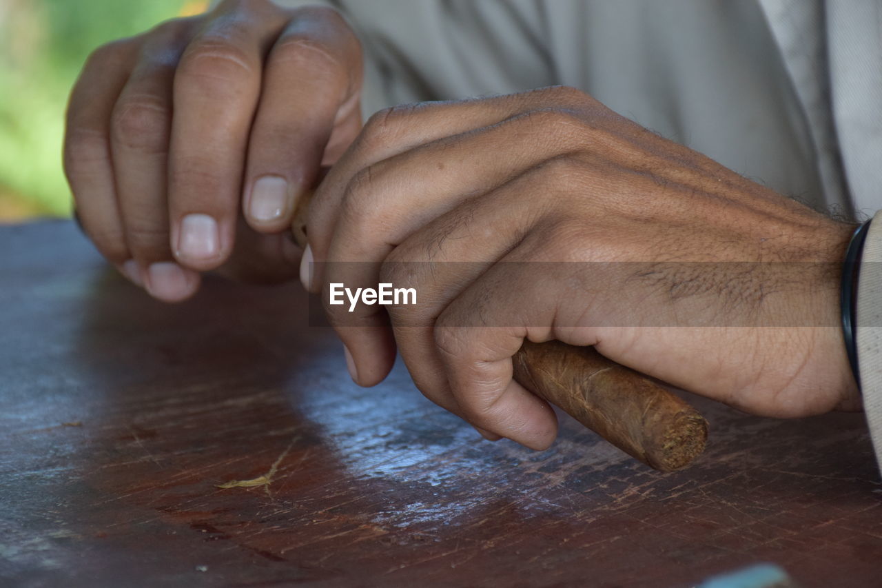 Close-up of man holding hands on table