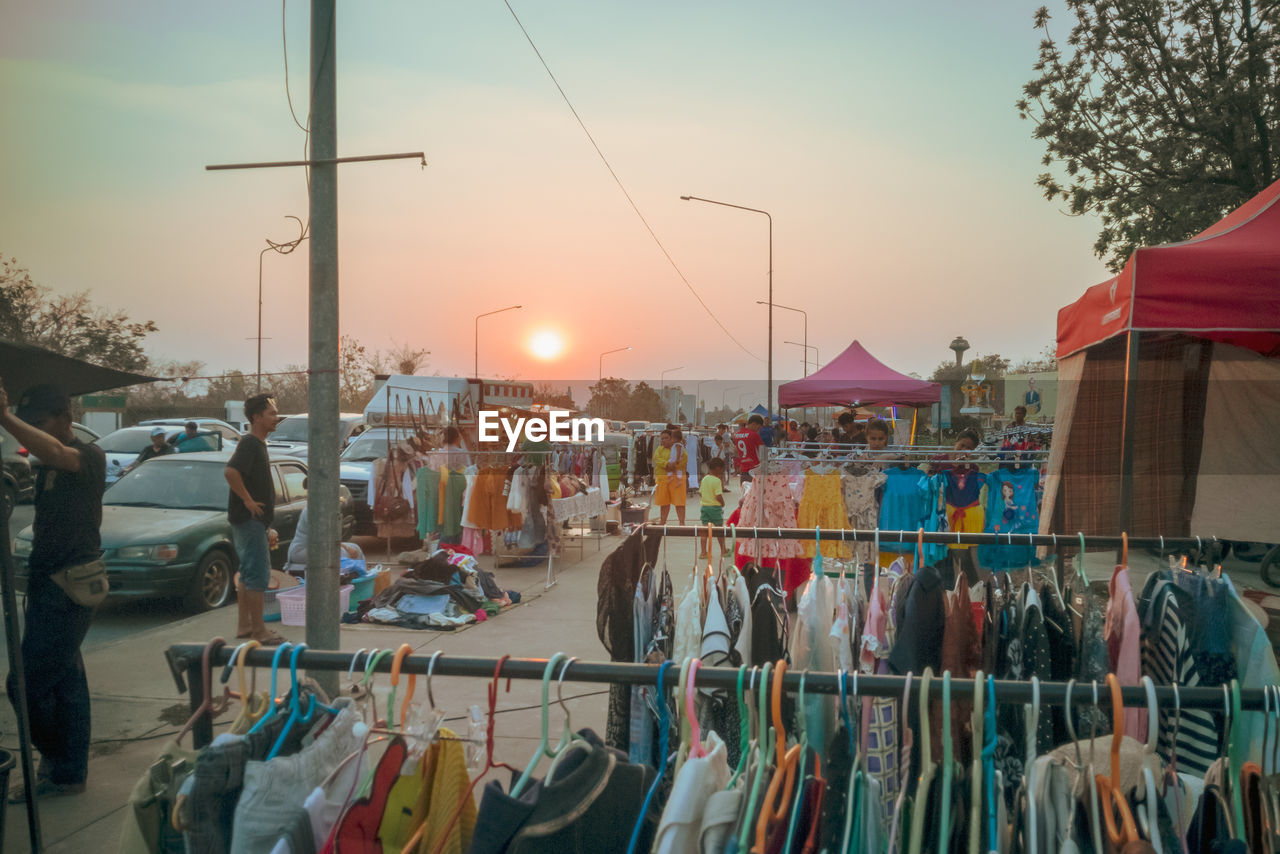 PEOPLE AT STREET MARKET IN CITY AGAINST SKY