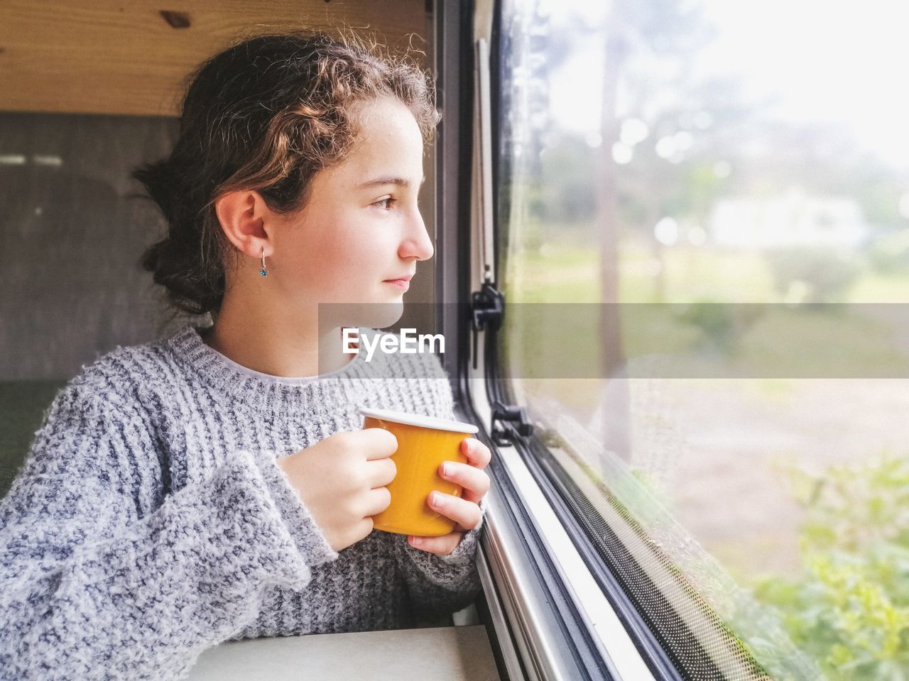 Young woman looking through window