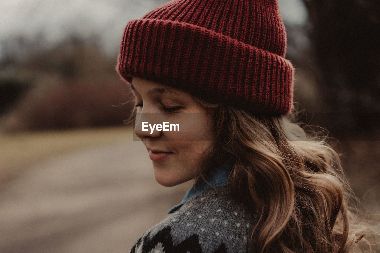 Close-up of woman with eyes closed wearing knit hat