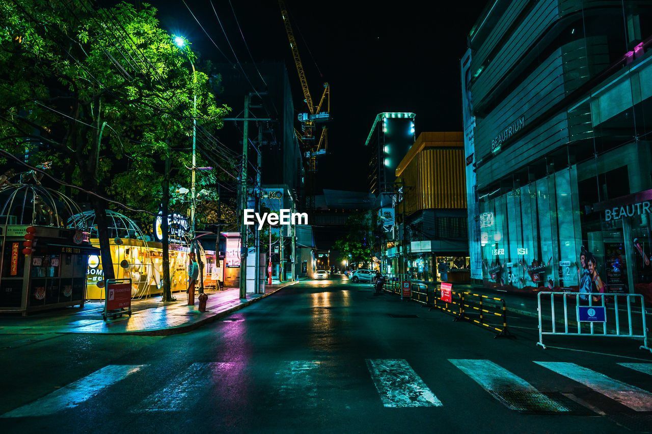 Illuminated city street and buildings at night