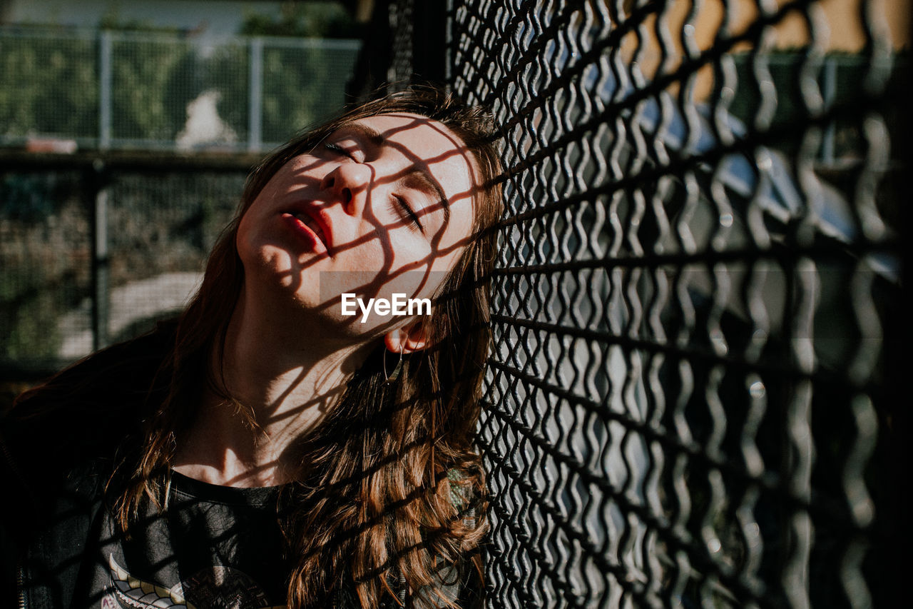 A face of yang woman with a closed eyes . on her face to fall a thin-lines shadows.