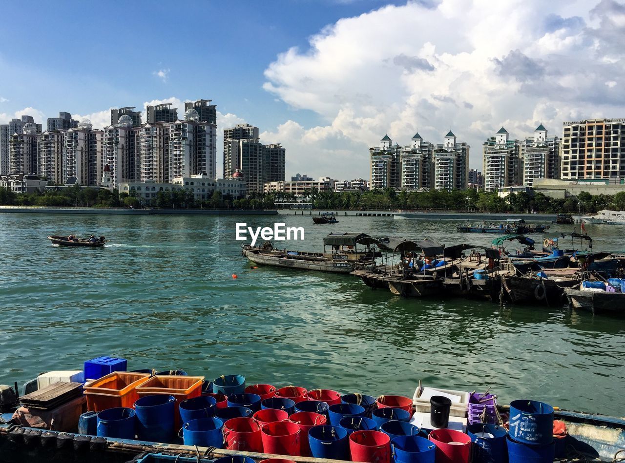 BOATS IN SEA AGAINST SKY IN CITY