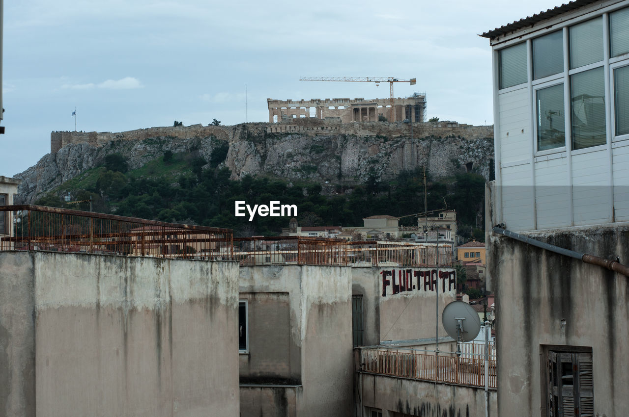 Acropole view in the background, behind the backside of old buildings.