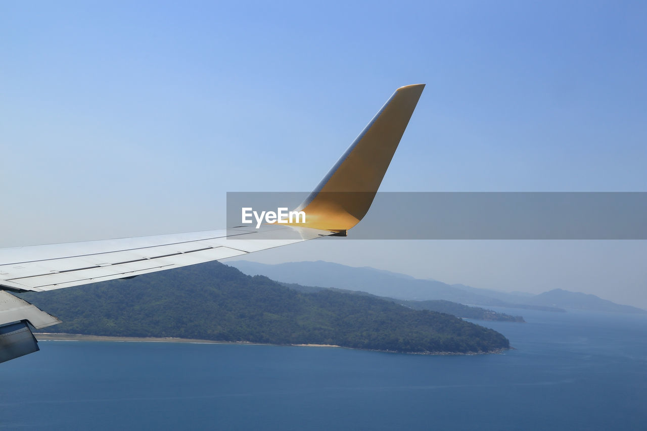 AIRPLANE FLYING OVER SEA AGAINST SKY