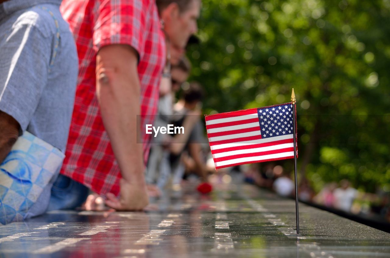 People by american flag at national september 11 memorial and museum