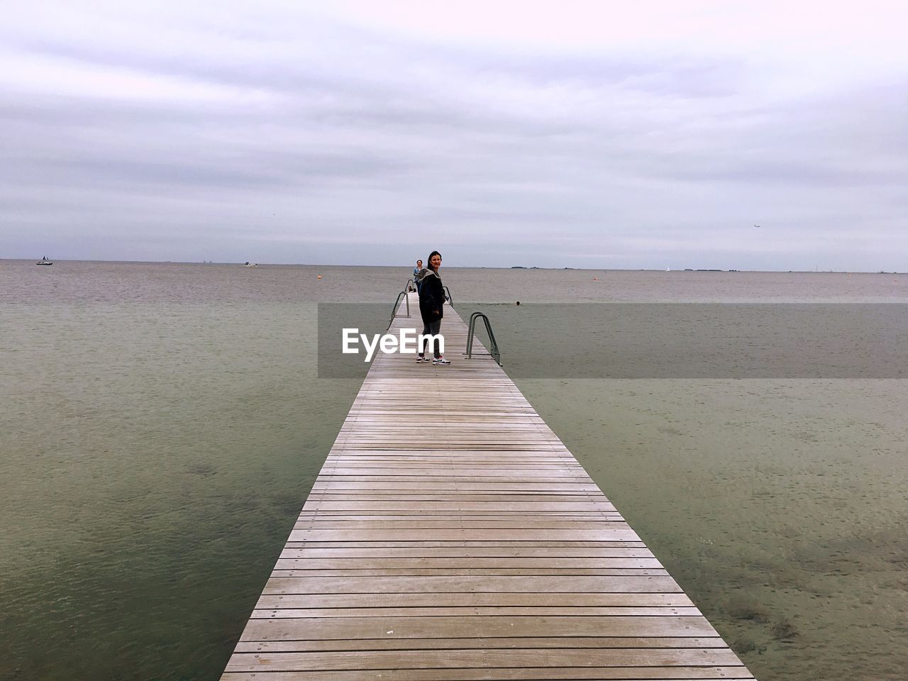 MAN STANDING ON BEACH AGAINST SEA