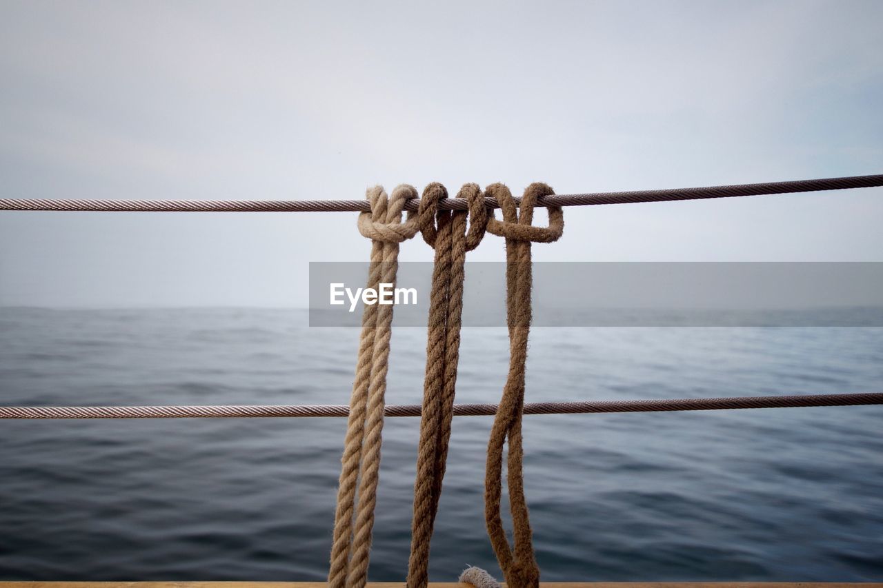 Close-up of ropes tied on railing
