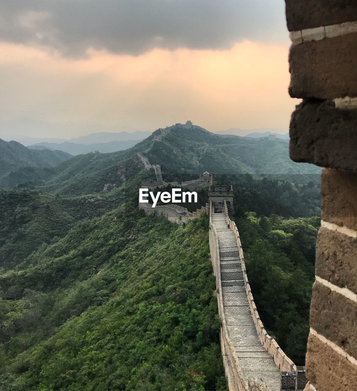 Great wall of china on mountains against cloudy sky during sunset