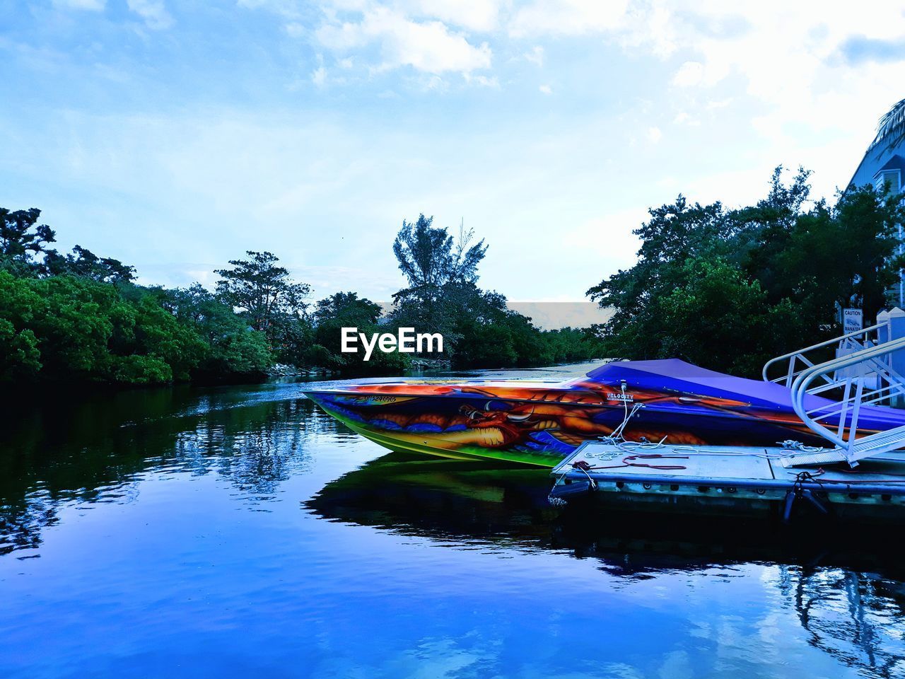 BOATS MOORED IN SEA AGAINST BLUE SKY